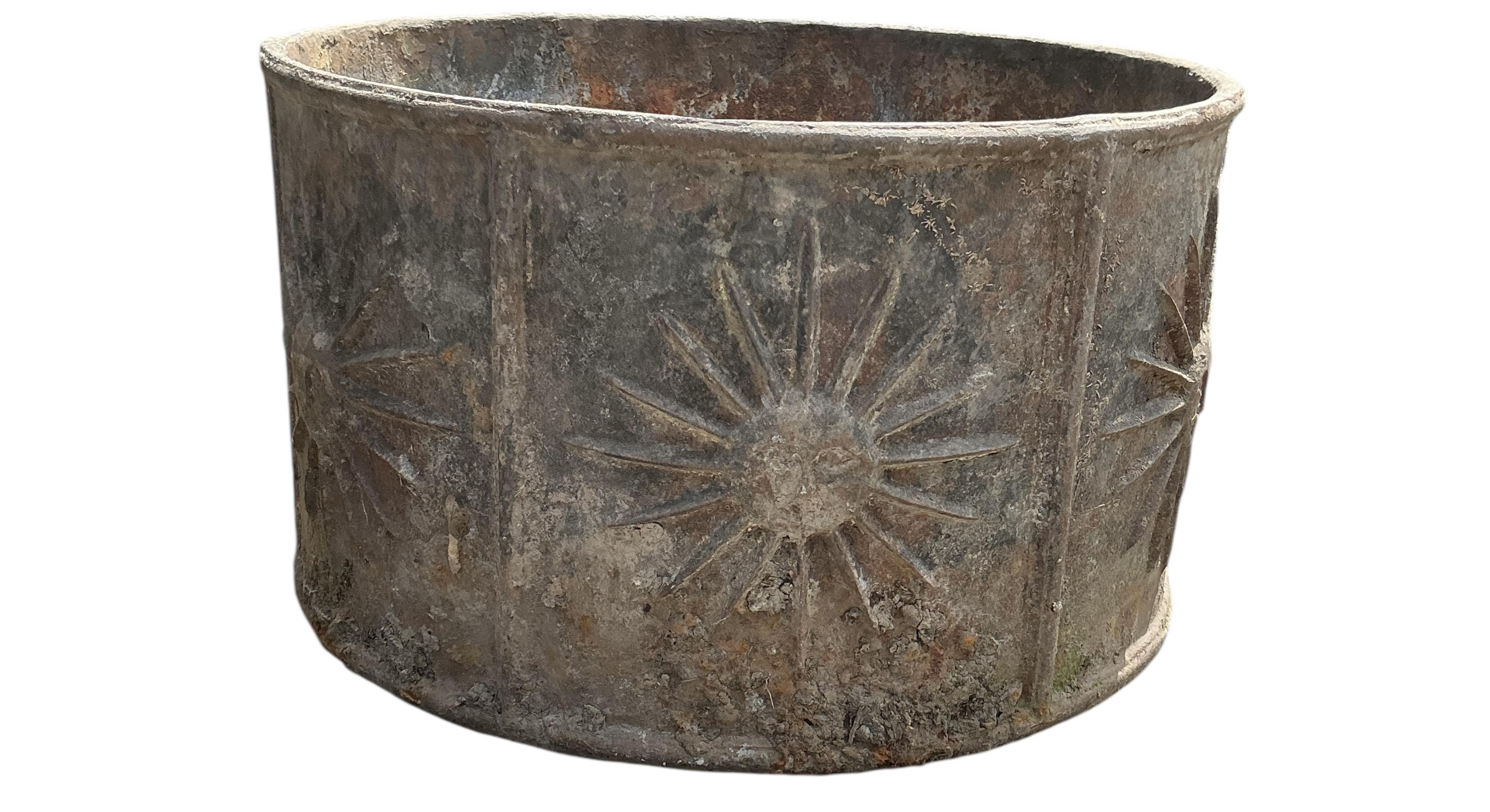 A pair of circular iron planters with cast relief sunburst panels, diameter 52cm, height 30cm